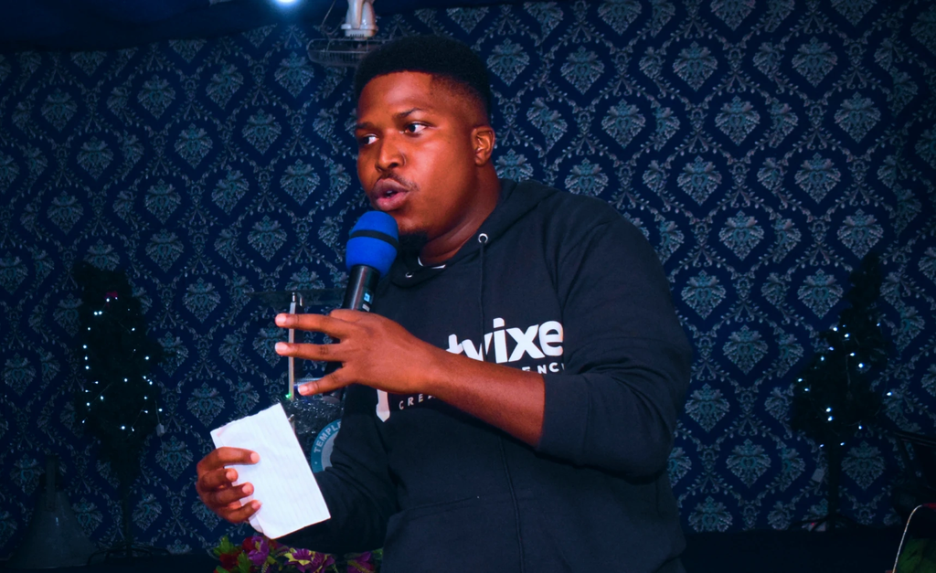 Ulu Oluebubechukwu speaking into a microphone during a live session
